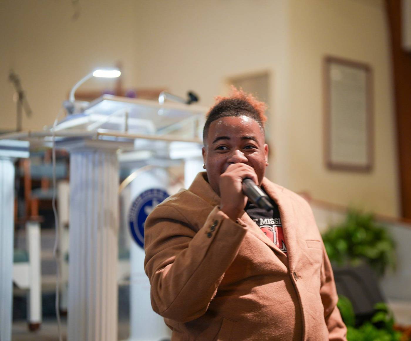 A man singing into a microphone at the pulpit