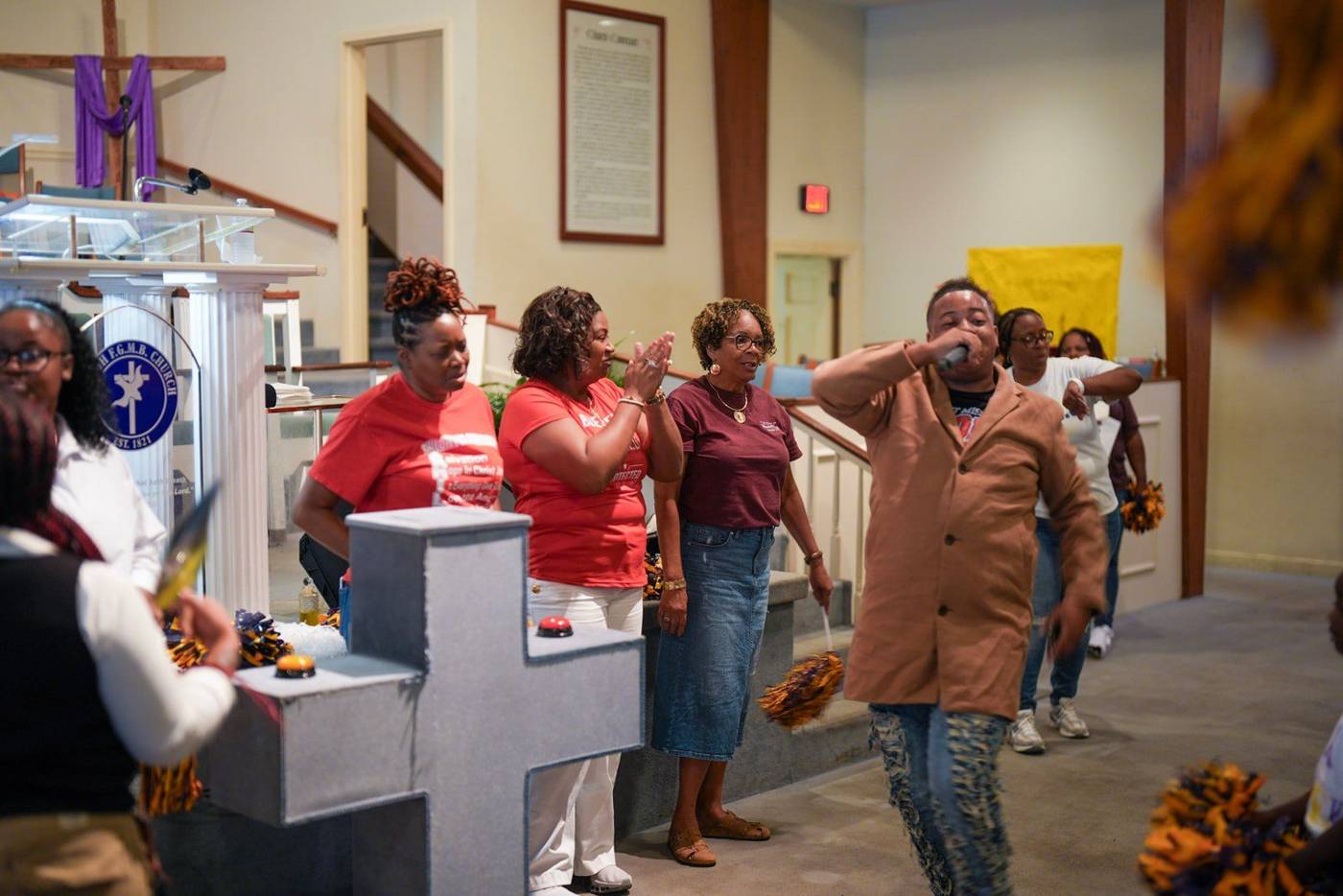 Women in red shirts praising at the front of the church